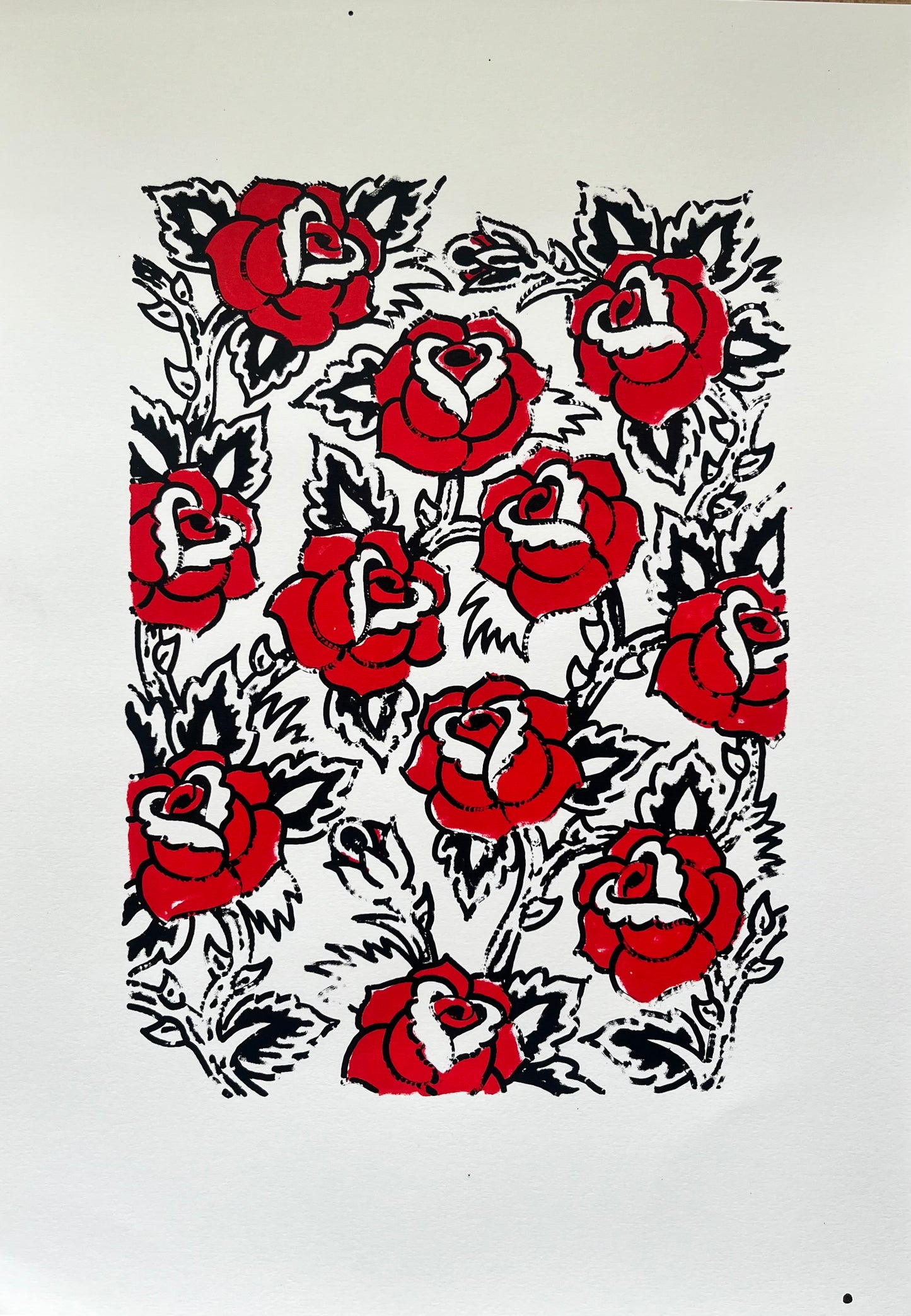 A two colour black and red screen print of a floral pattern of sailor Jerry style roses in a tattoo design style
