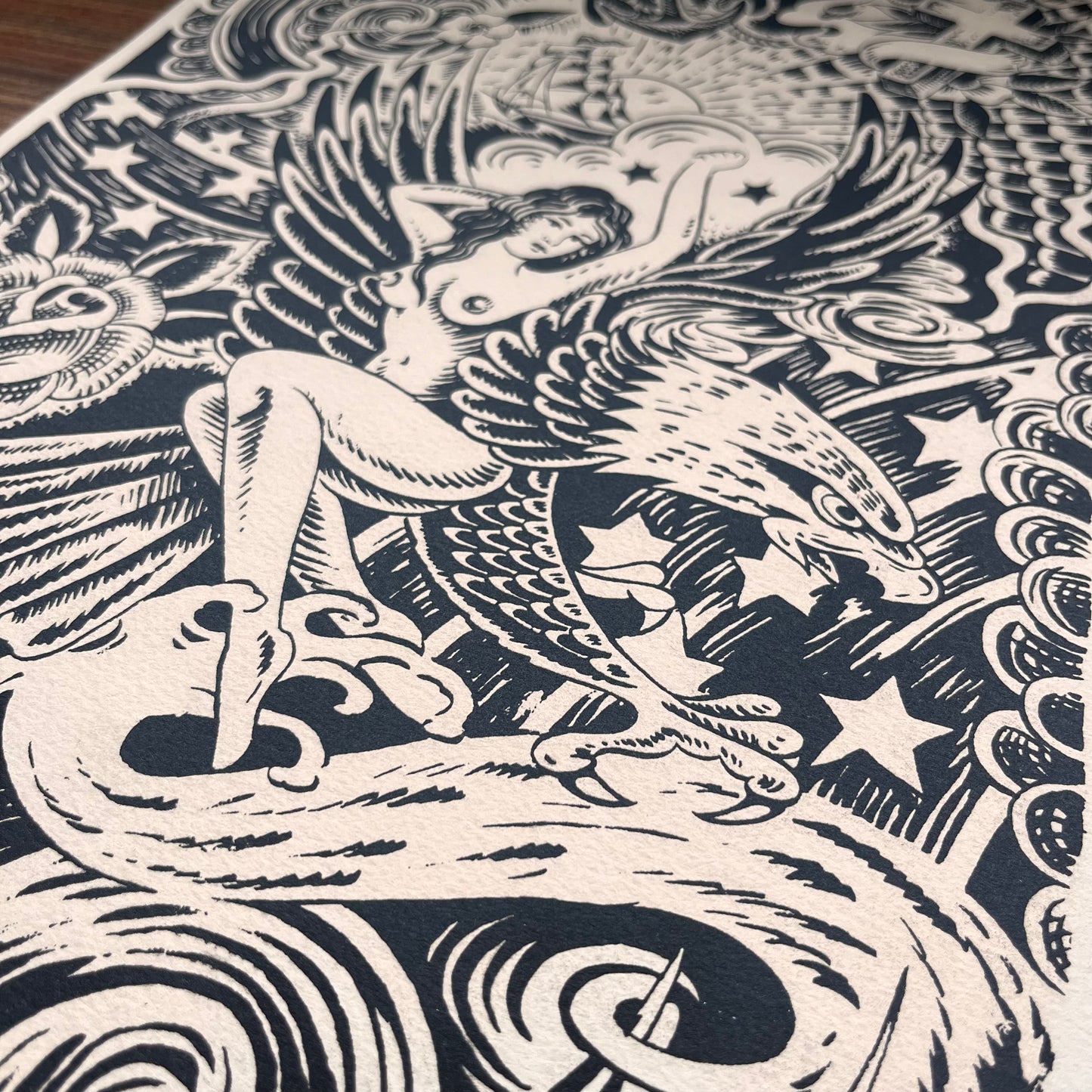 Black and white tattoo design brush pen illustration featuring Japanese background of waves, clouds, and lightening. An Ed hardy woman on an eagle, a skull, a rose, and a ship