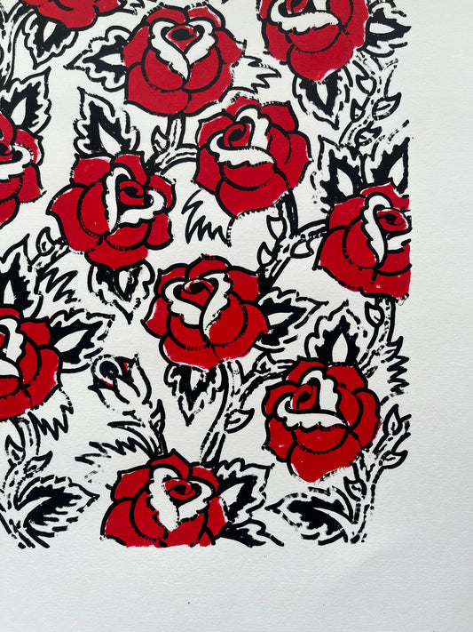 A two colour black and red screen print of a floral pattern of sailor Jerry style roses in a tattoo design style 