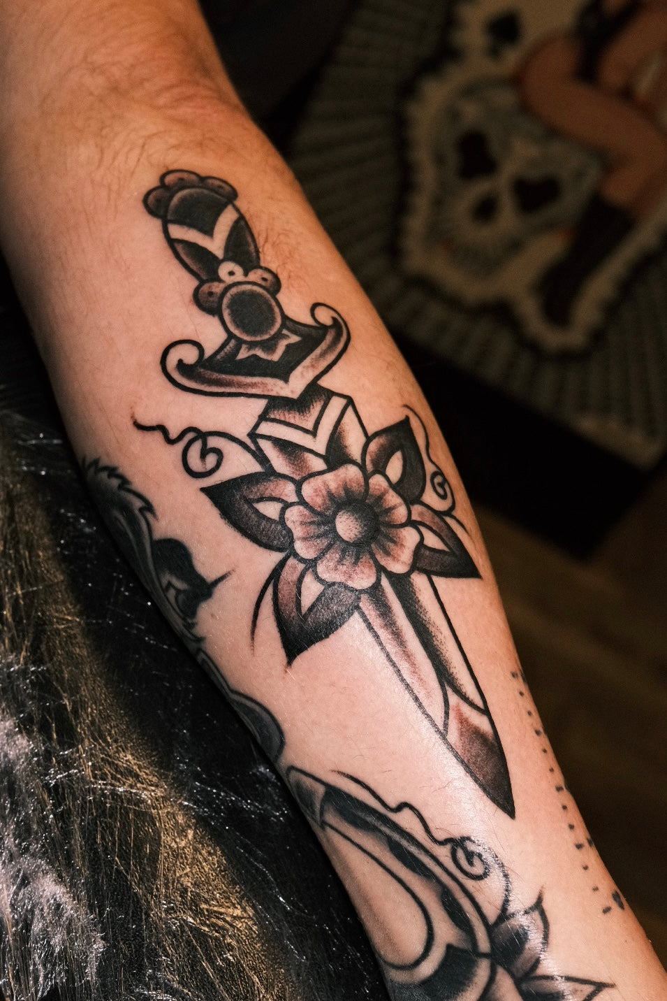 Bold American traditional classic black and grey dagger tattoo with a flower. Done in London by jake cordal at frith street tattoo