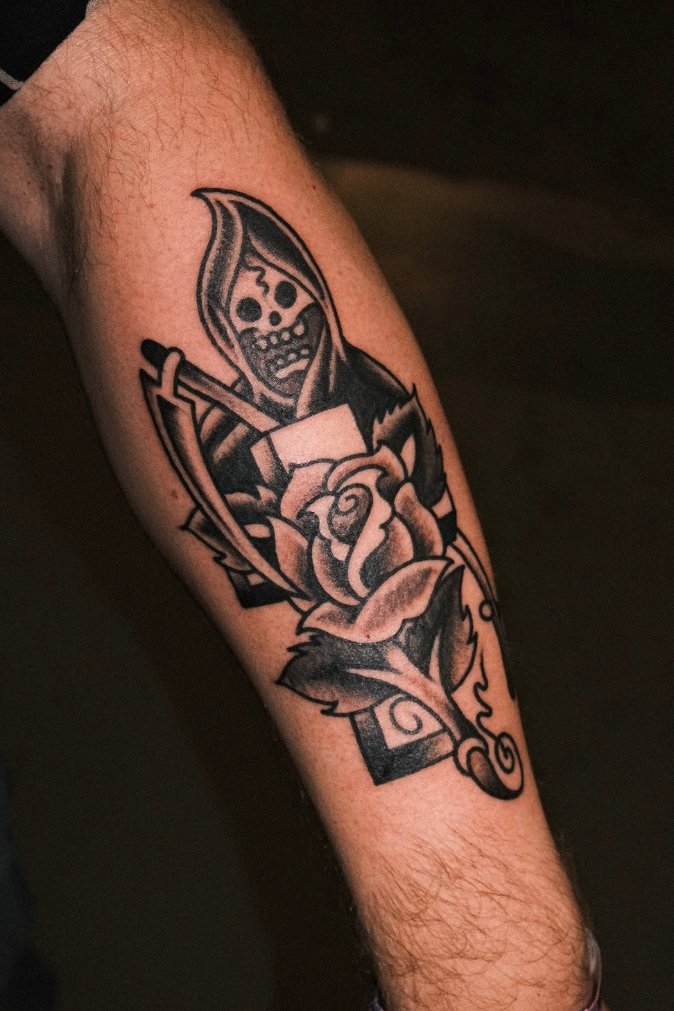 Bold American traditional classic black and grey grim reaper tattoo with a rose and cross. Done in London by jake cordal at frith street tattoo