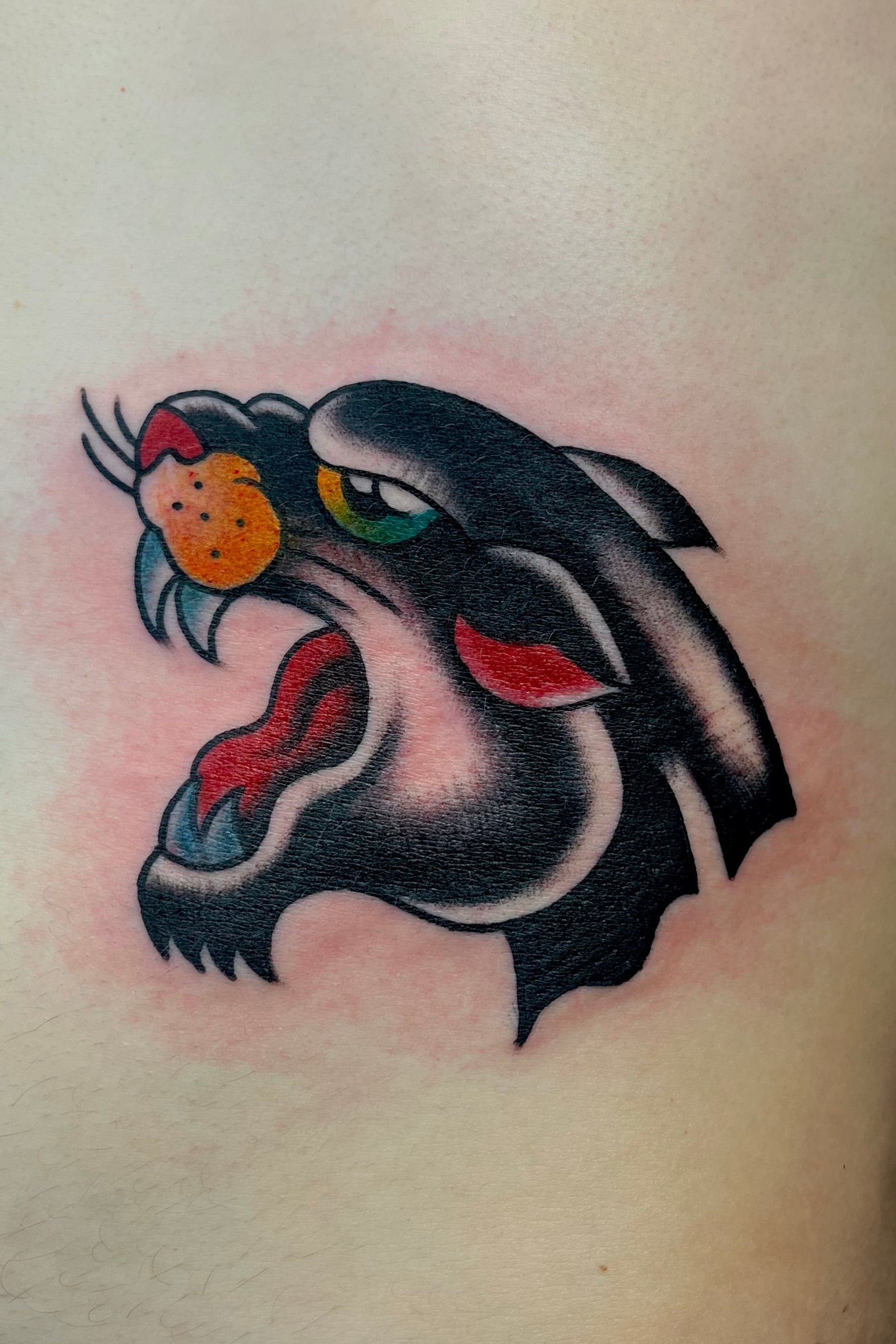 bold american traditional panther head tattoo in full colour. tattooed at frith street tattoo, london