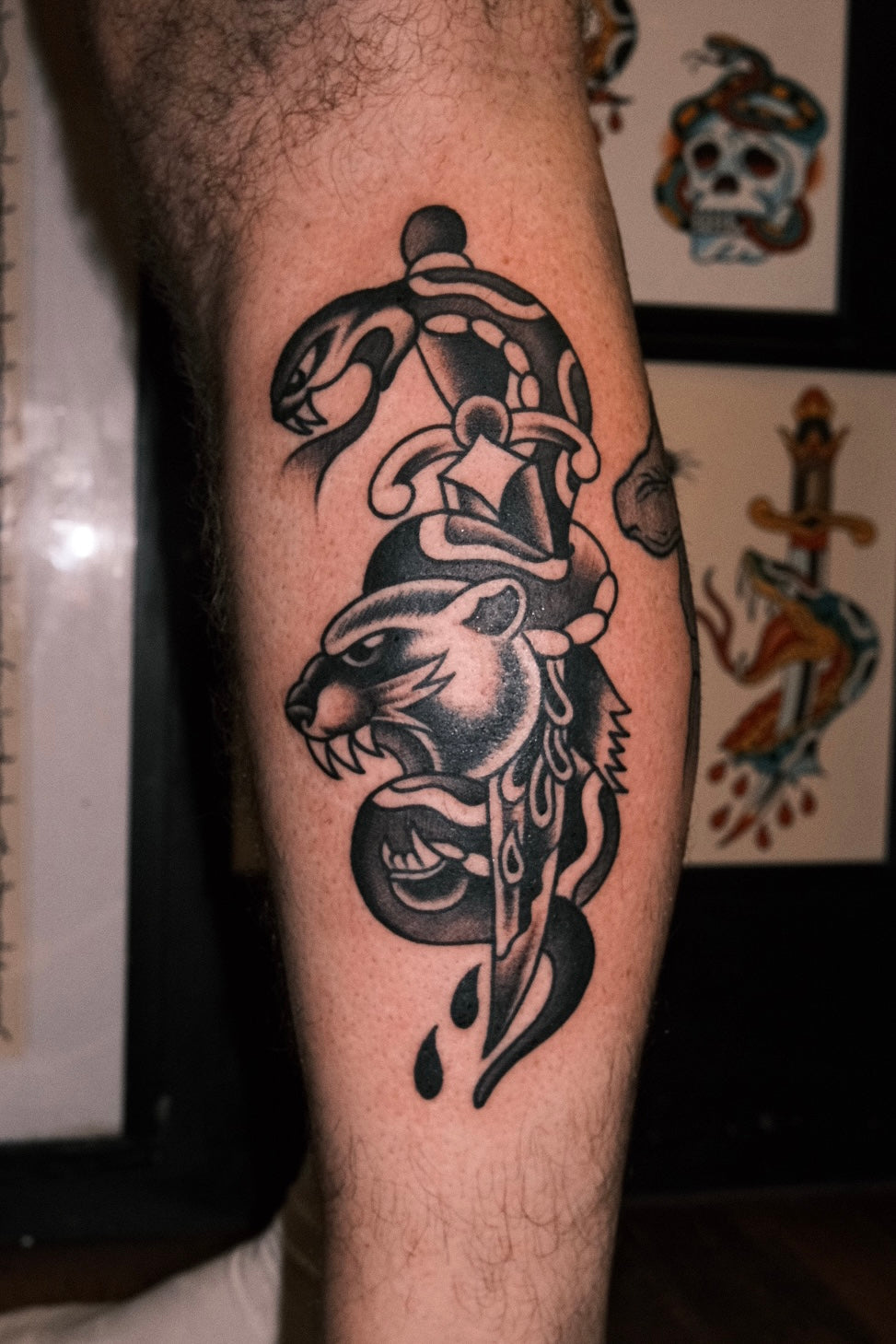 Bold American traditional classic black and grey dagger tattoo with a panther and snake. Done in London by jake cordal at frith street tattoo