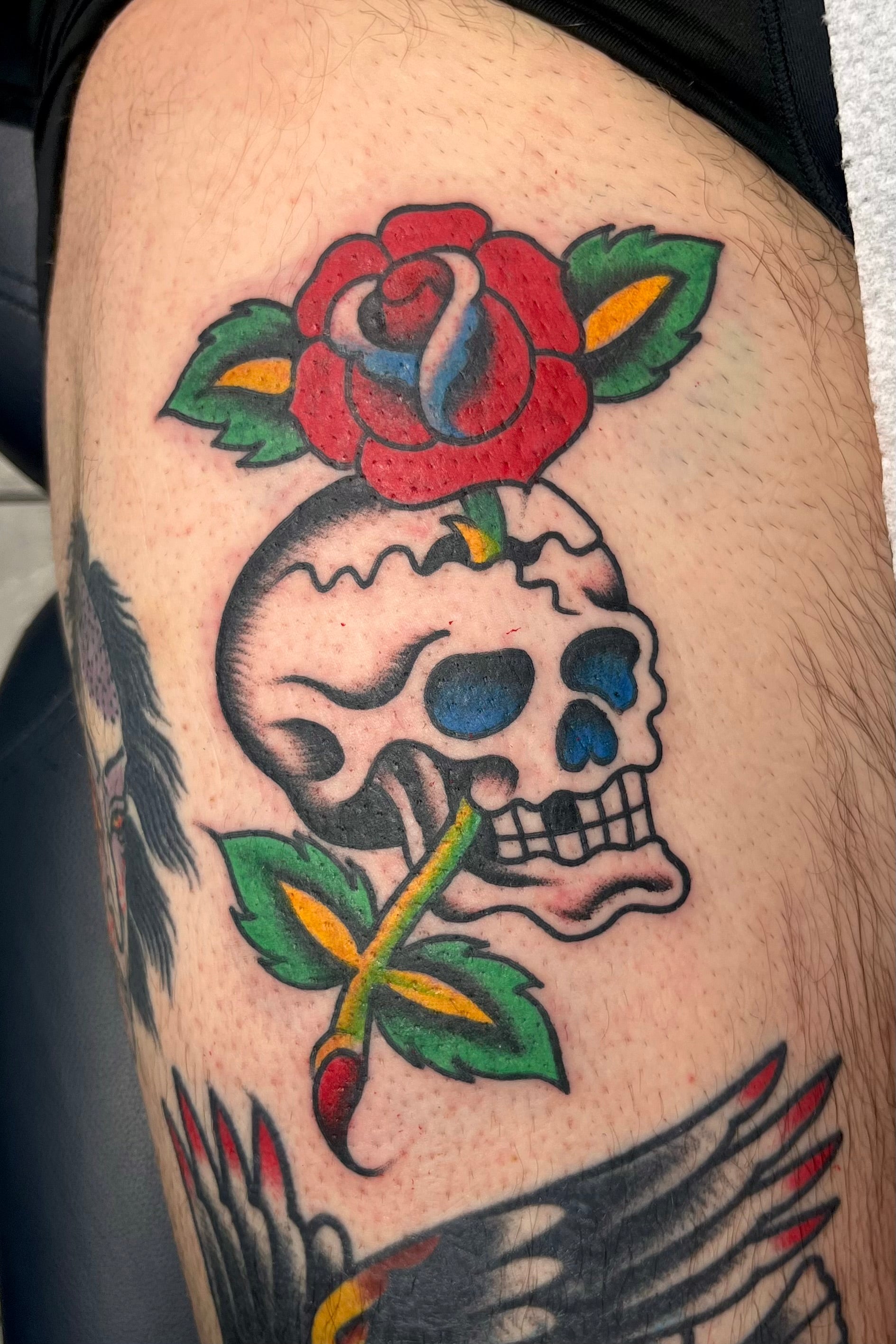 Colourful Bold American traditional classic sailor jerry skull and rose tattoo. Tattooed in London.