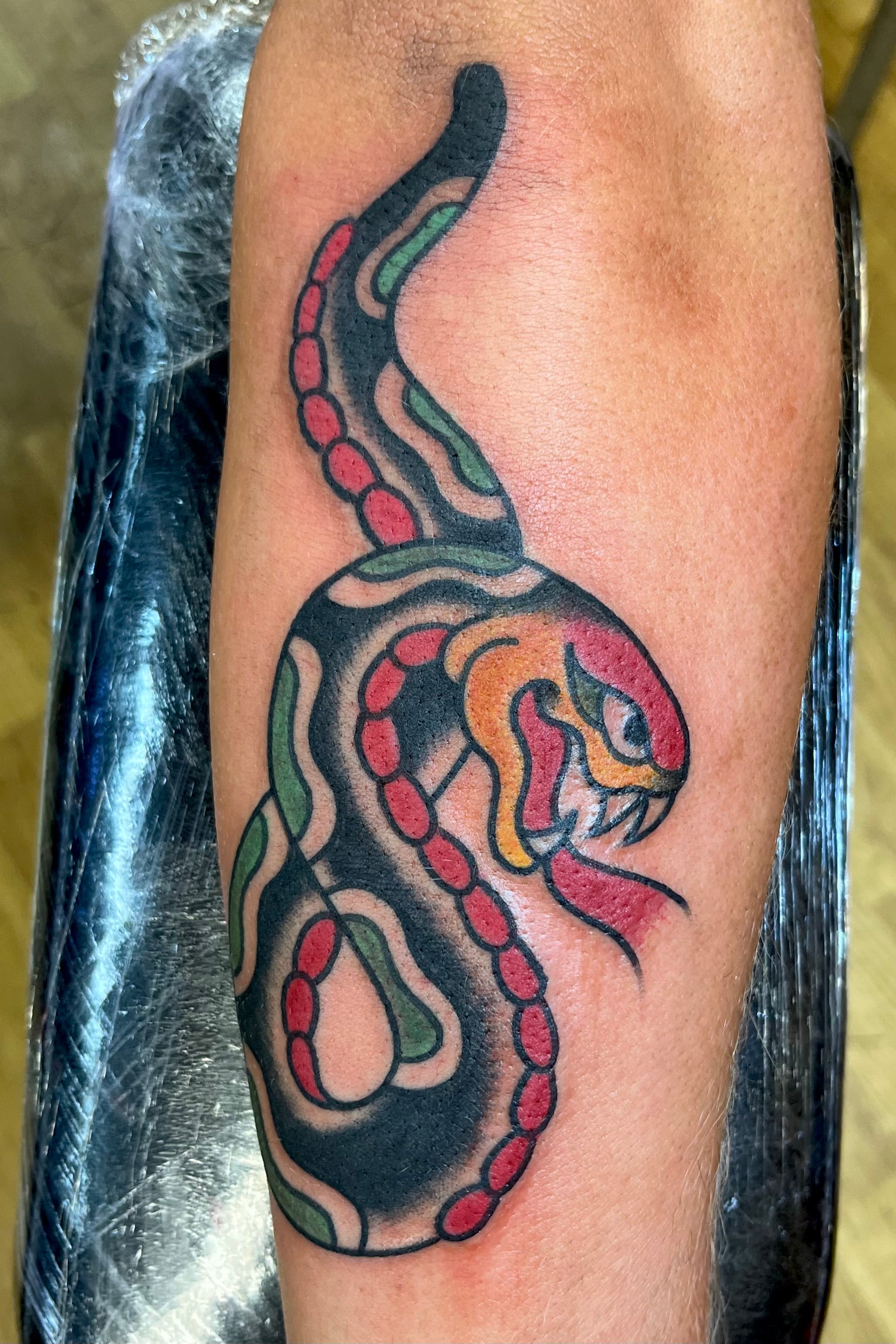 Bold American traditional classic forearm snake tattoo in colour. Tattooed in London