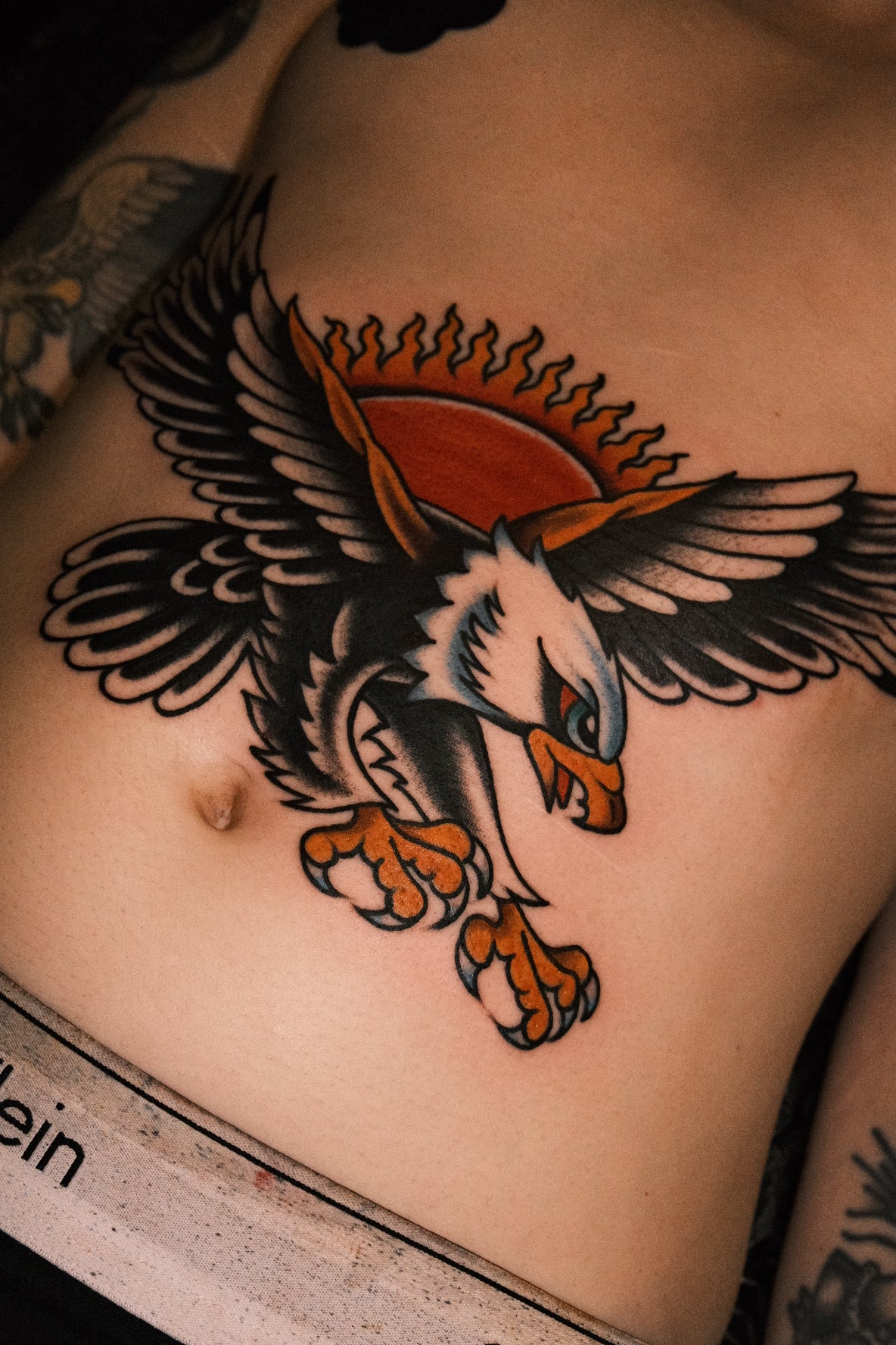 Bold American traditional classic swooping eagle stomach piece tattoo in colour. Done in London by jake cordal at frith street tattoo