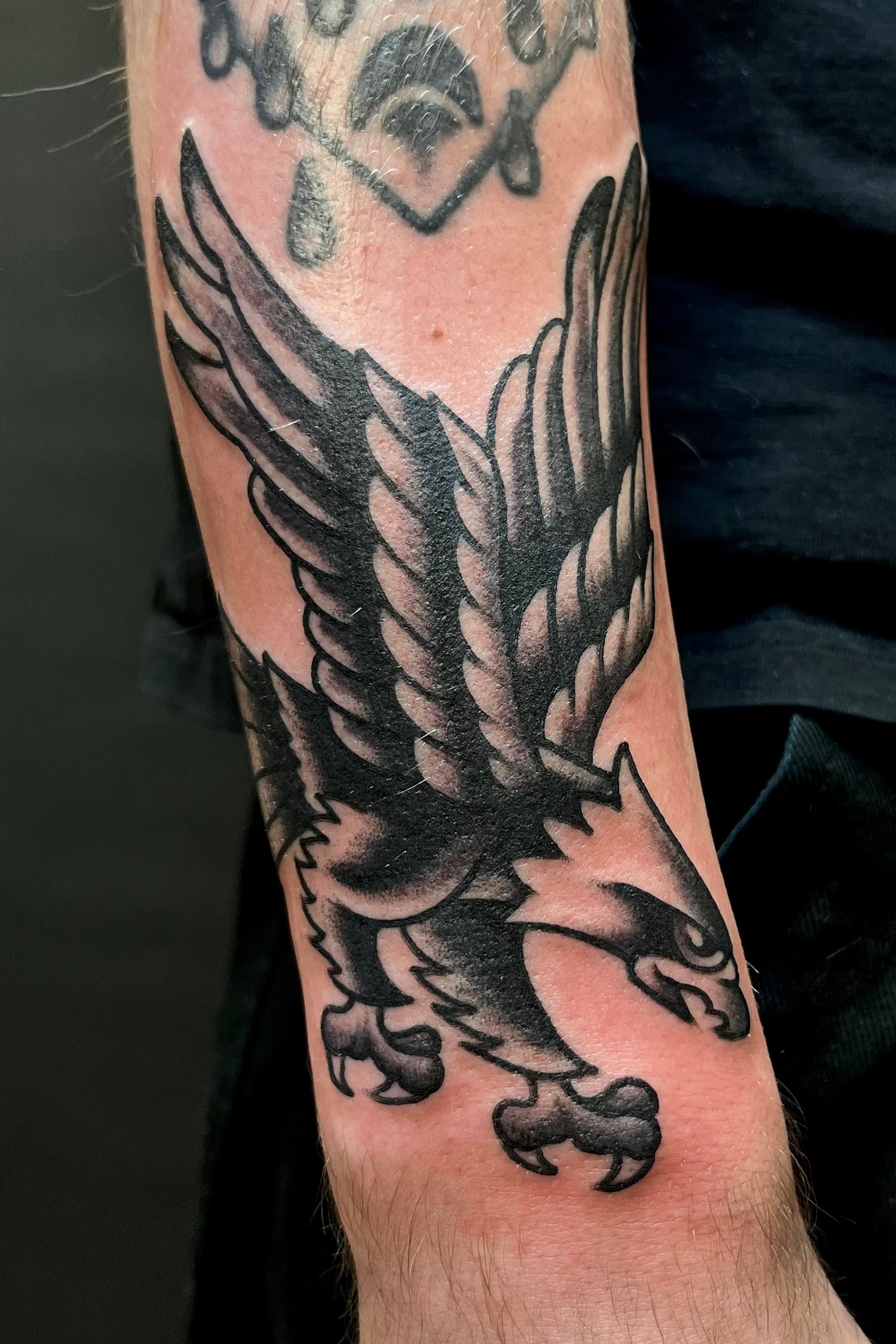 black and grey bold American traditional tattoo of an eagle on the forearm. tattooed in london at frith street tattoo