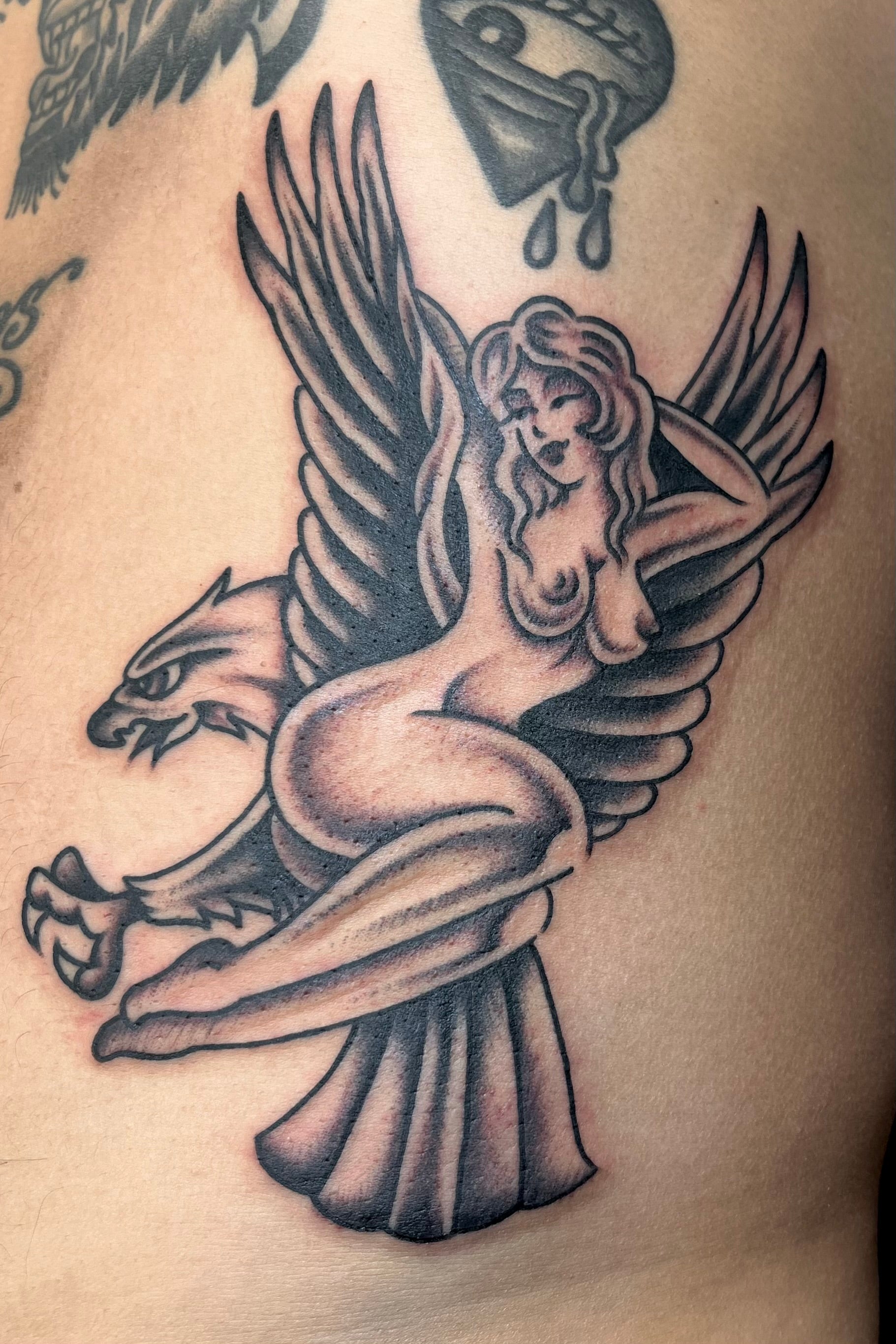 Bold American traditional classic Black and grey sailor Jerry eagle tattoo with nude pin up on its back. Tattooed in London at frith street tattoo
